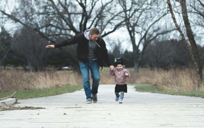 Father and daughter running together holding hands